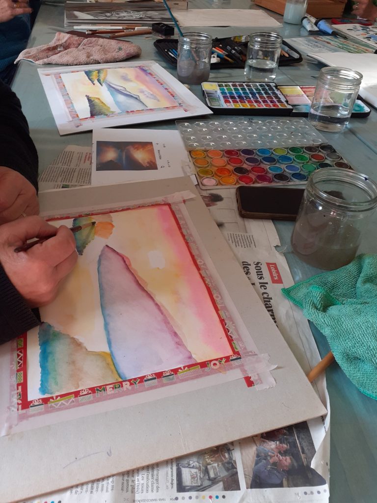 Personne entrain de finir son aquarelle de toutes les couleurs