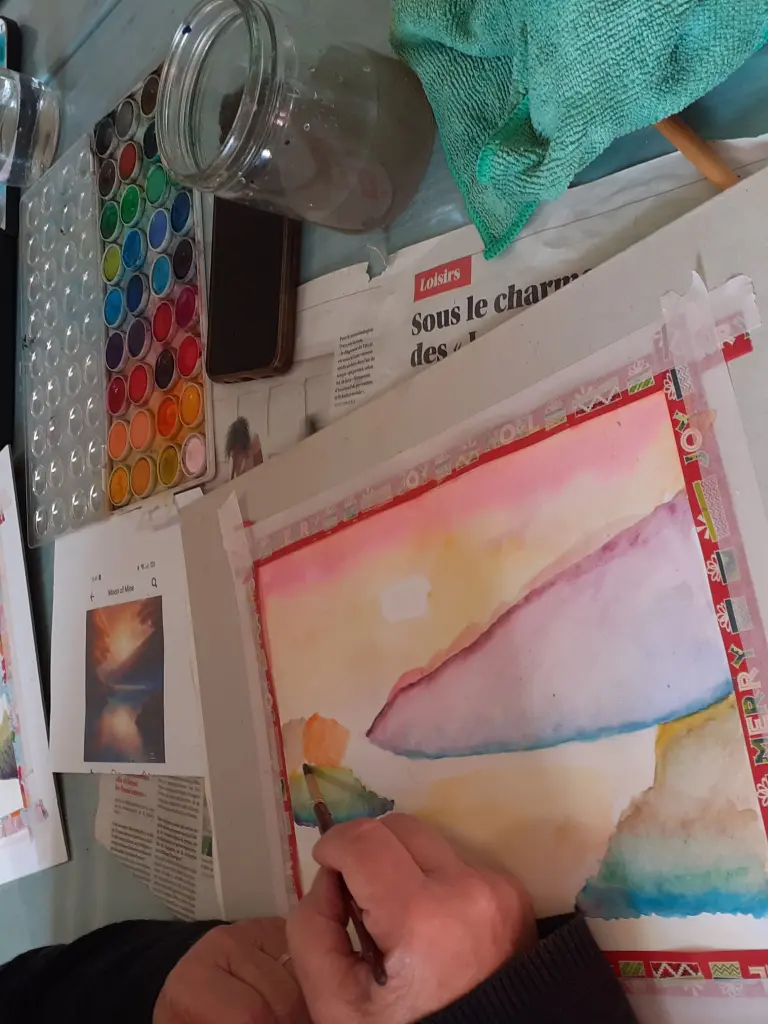 Personne entrain de finir son aquarelle de toutes les couleurs