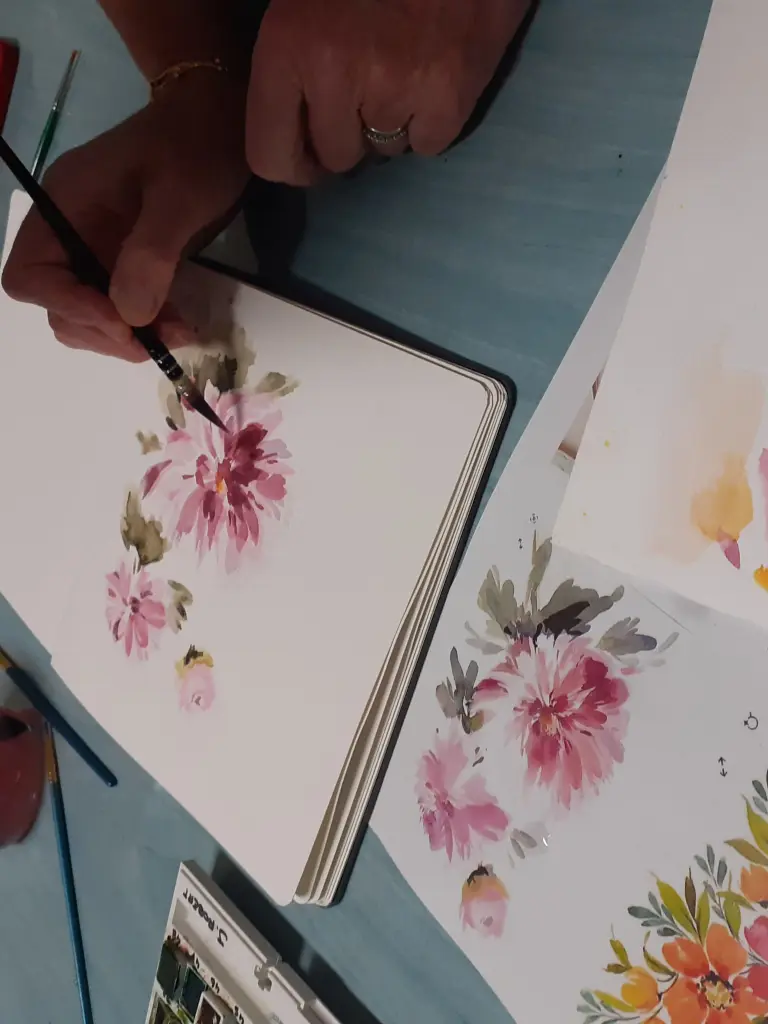 Personne entrain de peindre une fleur rose
