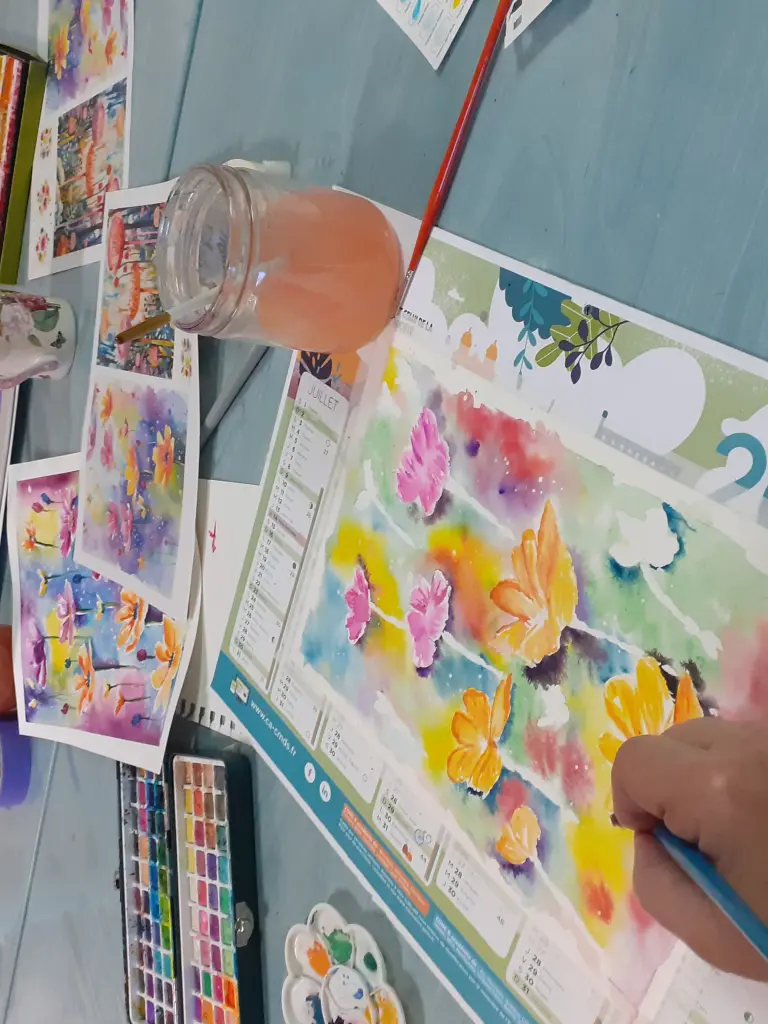 Personne entrain de peindre à l'aquarelle des fleurs de couleurs vives