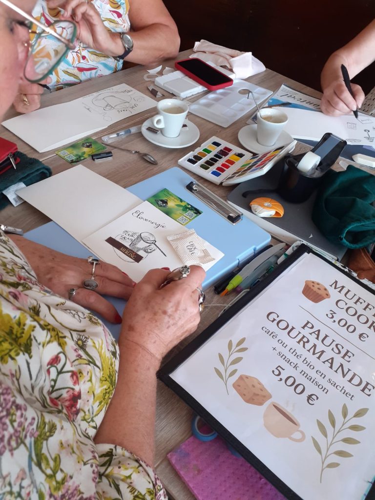 Personne entrain de peindre à l'aquarelle sur un carnet