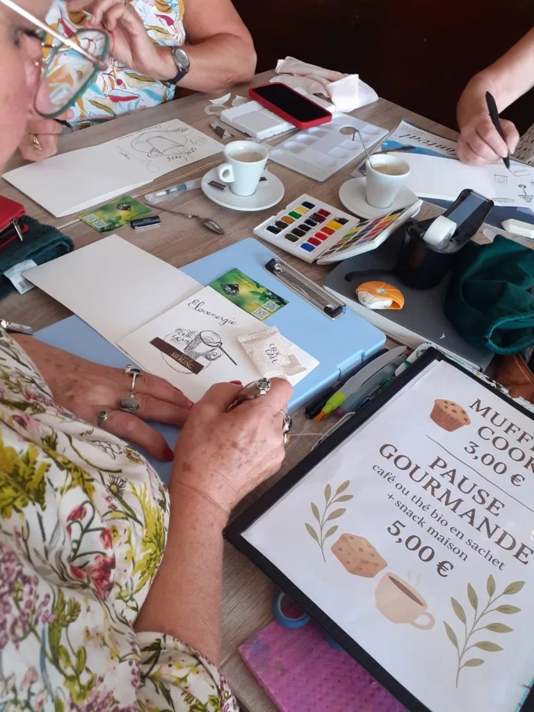 Personne entrain de peindre à l'aquarelle sur un carnet